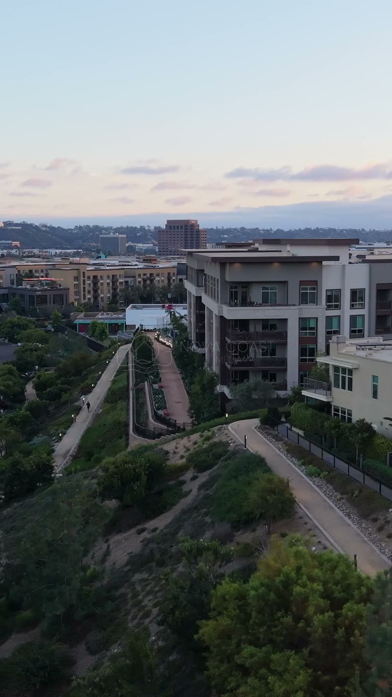 Civita Hilltop Residences Above the Community Garden Terraces at Dusk – Aerial View (Vertical)