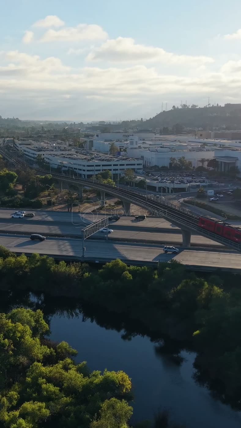 Trolley and Freeway Crossing the River Toward Mission Valley Mall at Sunset – Aerial View (Vertical)