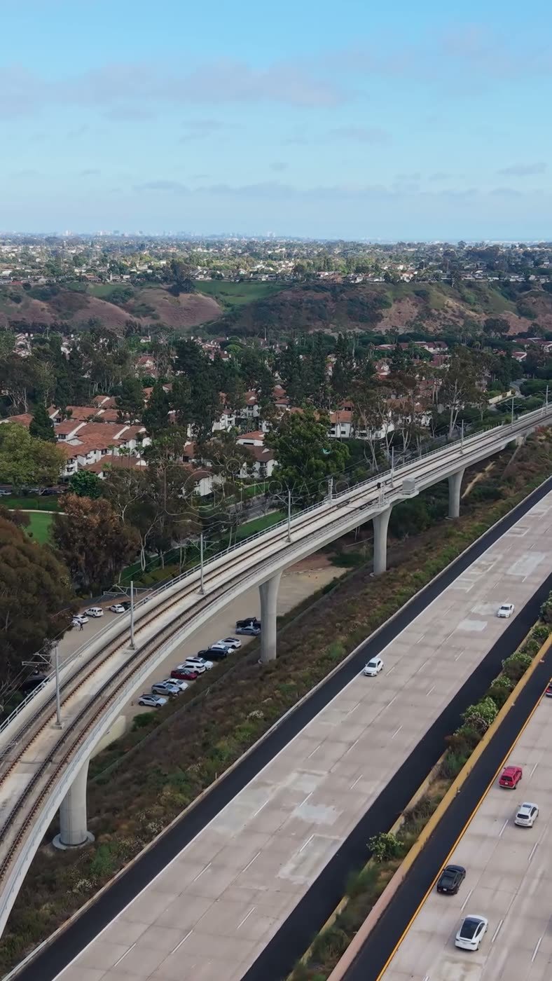 Elevated Trolley Guideway Curving Above the I-5 in University City – Wide Establishing Frame (Vertical)
