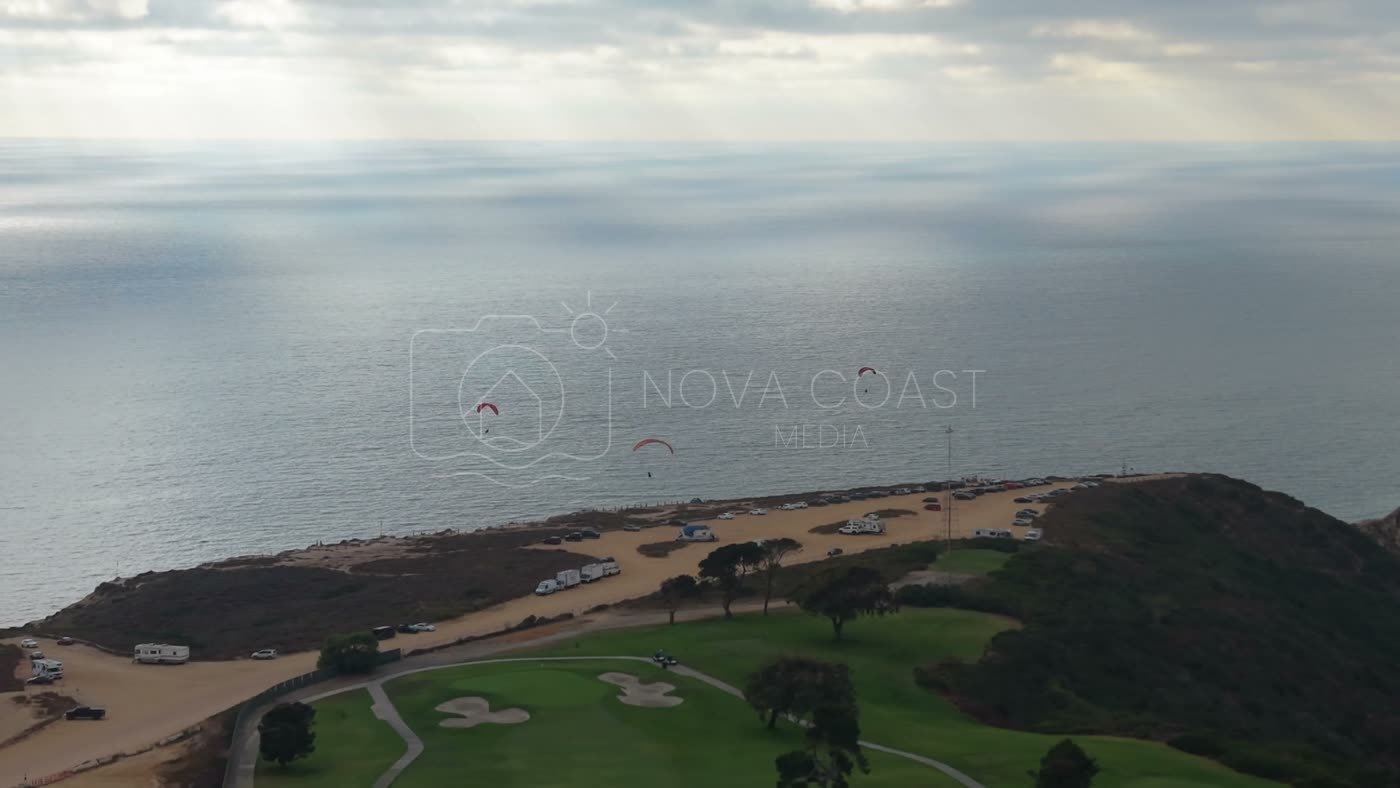Paragliders Soaring Over the Pacific at Torrey Pines Gliderport – Wide Establishing Frame