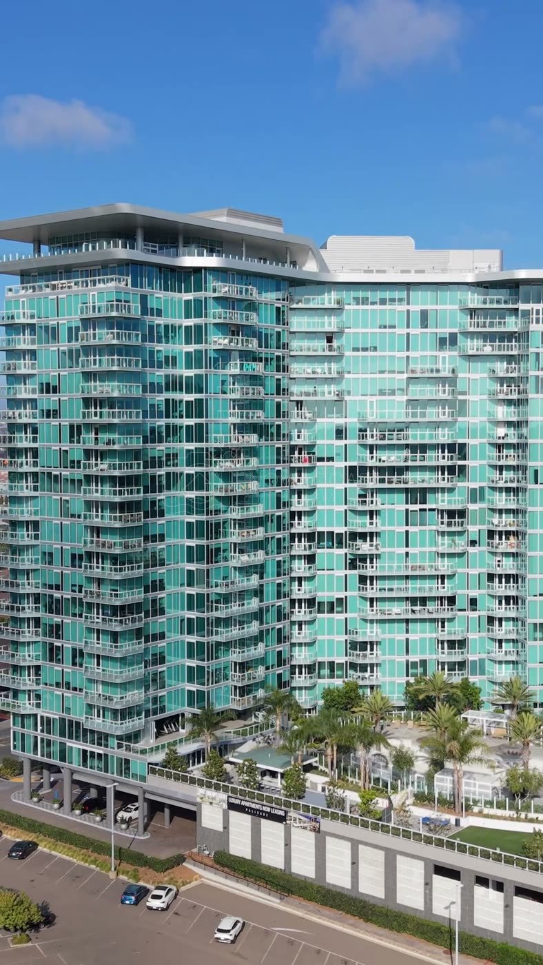 Glass High-Rise Residences at University Town Center Under Blue Skies – Wide Establishing Frame (Vertical)