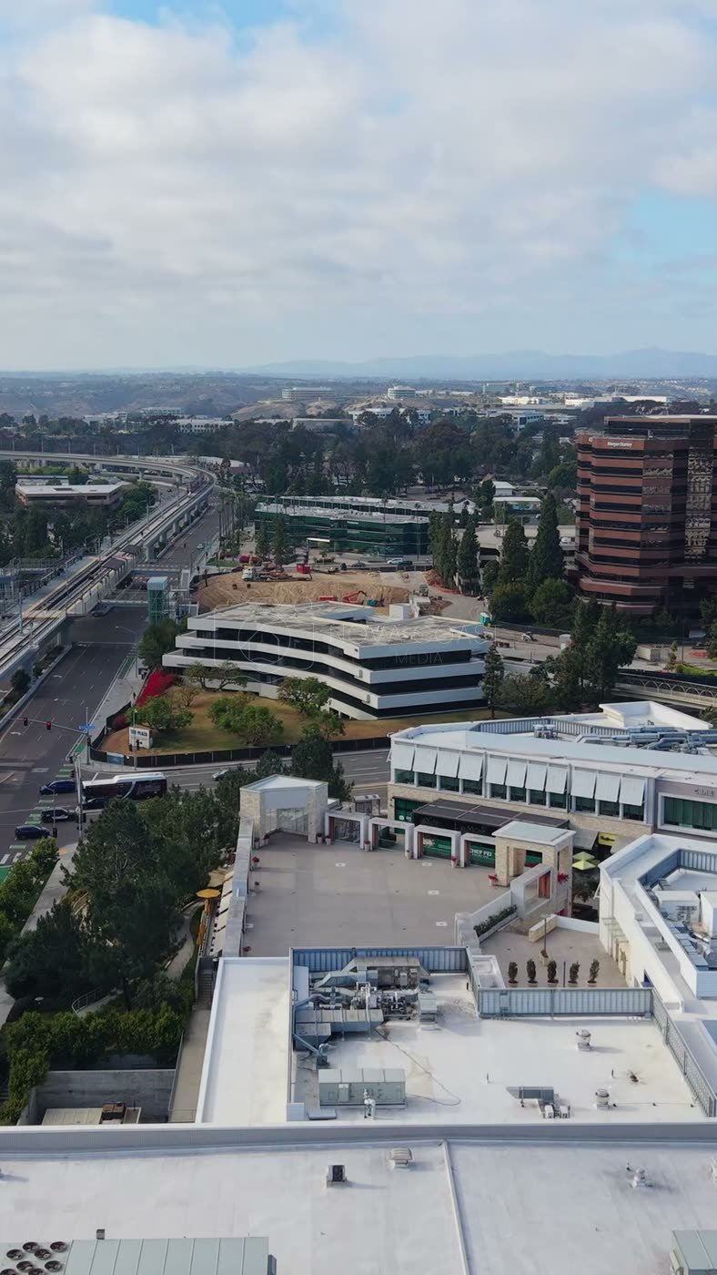 The Blue Line Trolley Threading Through University City’s Office District – Aerial View (Vertical)