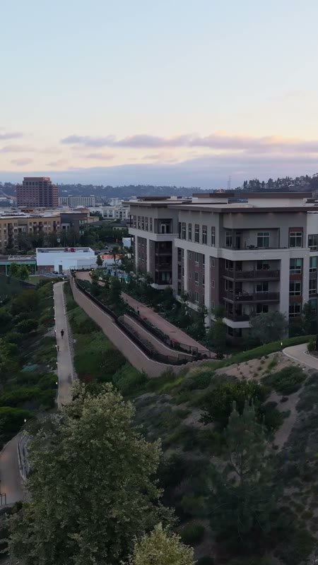 Civita Hilltop Residences Above the Community Garden Terraces at Dusk (Vertical)