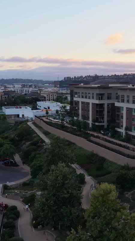 Civita Hilltop Residences Above the Community Garden Terraces at Dusk – Wide Establishing Frame (Vertical)