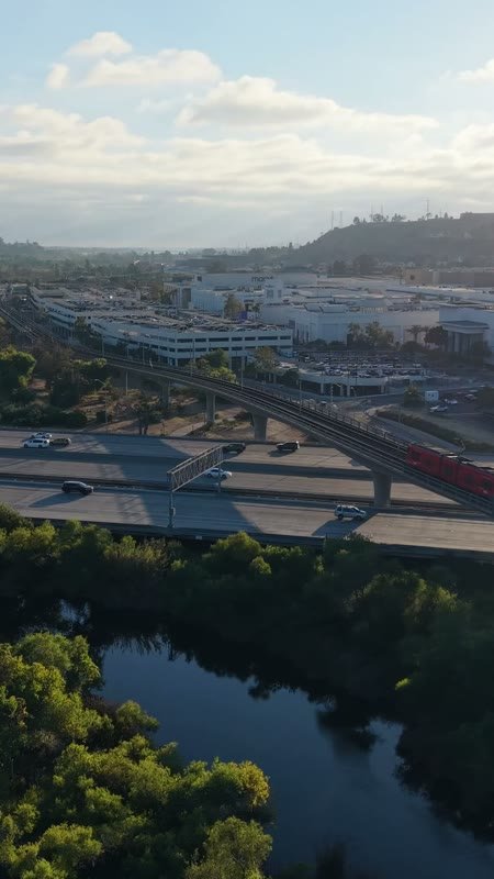 Trolley and Freeway Crossing the River Toward Mission Valley Mall at Sunset – Aerial View (Vertical)