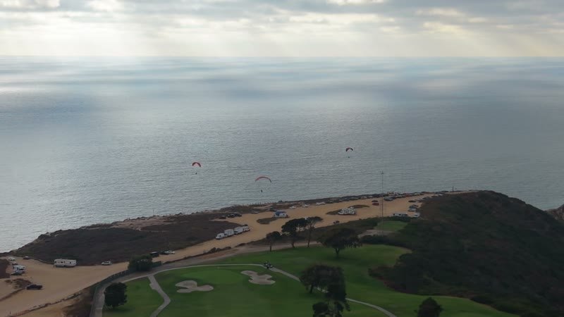 Paragliders Soaring Over the Pacific at Torrey Pines Gliderport – Wide Establishing Frame