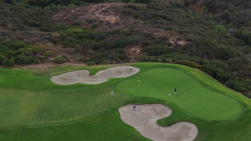 Golfers on a Clifftop Green Between Sculpted Bunkers at Torrey Pines