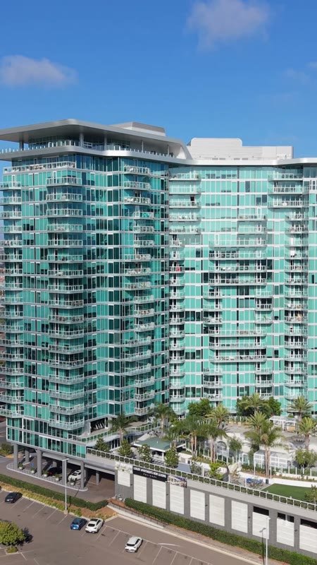 Glass High-Rise Residences at University Town Center Under Blue Skies – Wide Establishing Frame (Vertical)